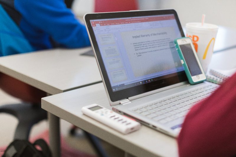 Student viewing lecture slides on laptop and ready to participate in class poll with i-clicker.