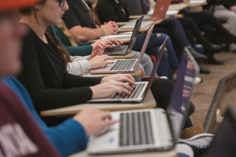 Row of students with laptops.