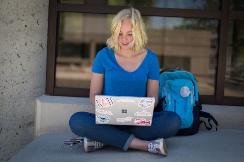 Student studying outside with a laptop.