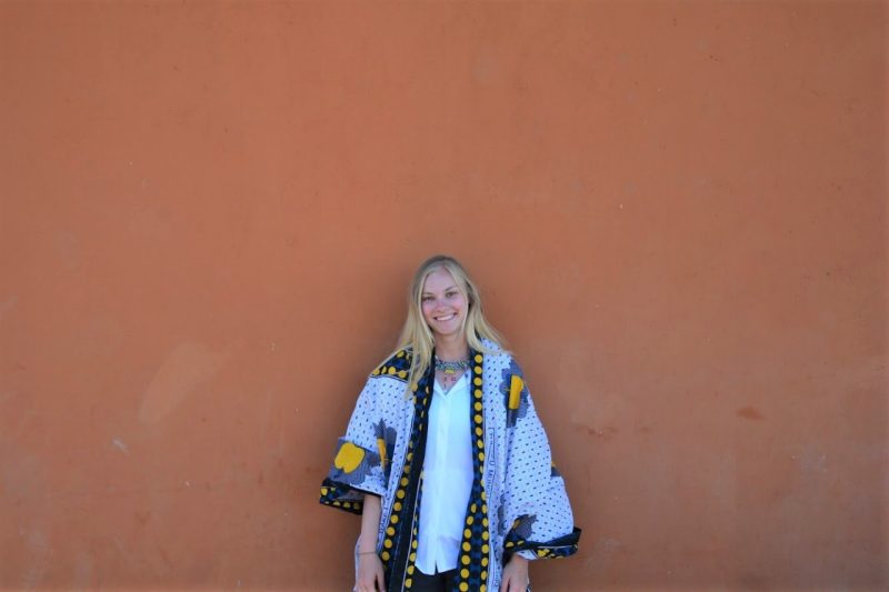 young woman in elegant robe against clay wall