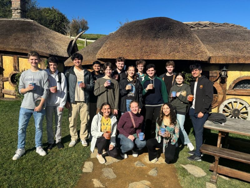 A group of students standing in front of cottages