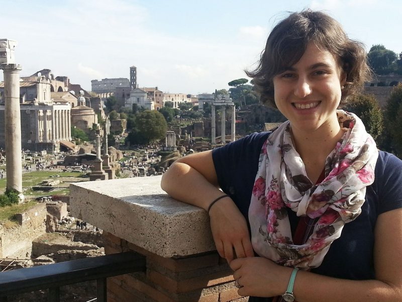 Young woman posing in front of  Roman ruins 