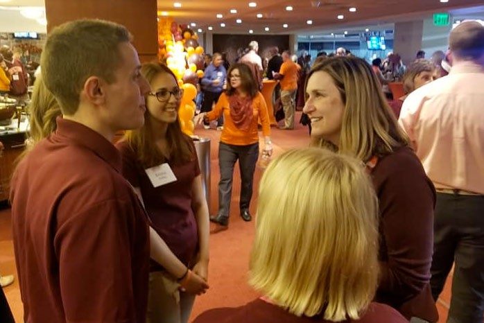 Dean Ross talking with students at an event.