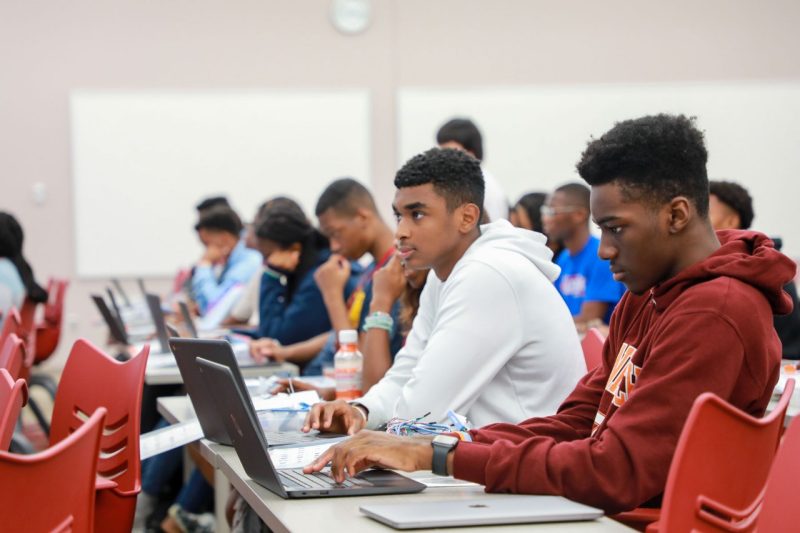 students working on laptops in a classroom