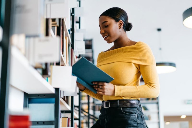 student reading a book in a library