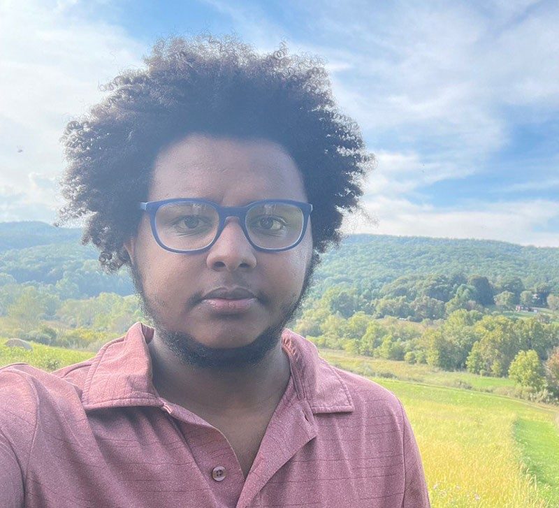 Selfie of Fasil Gebreab with a mountain in the background