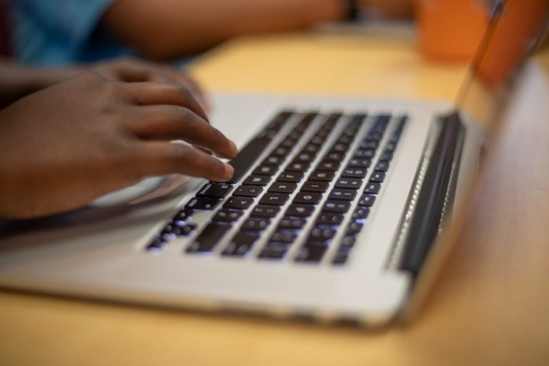 student typing on a laptop, only hands and laptop keyboard are shown