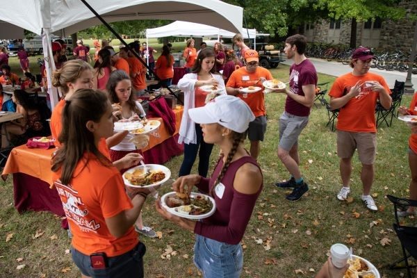 Alumni mingle and eat at a football tailgate