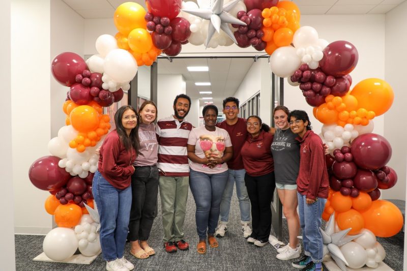 CEED students stand under a balloon arch.