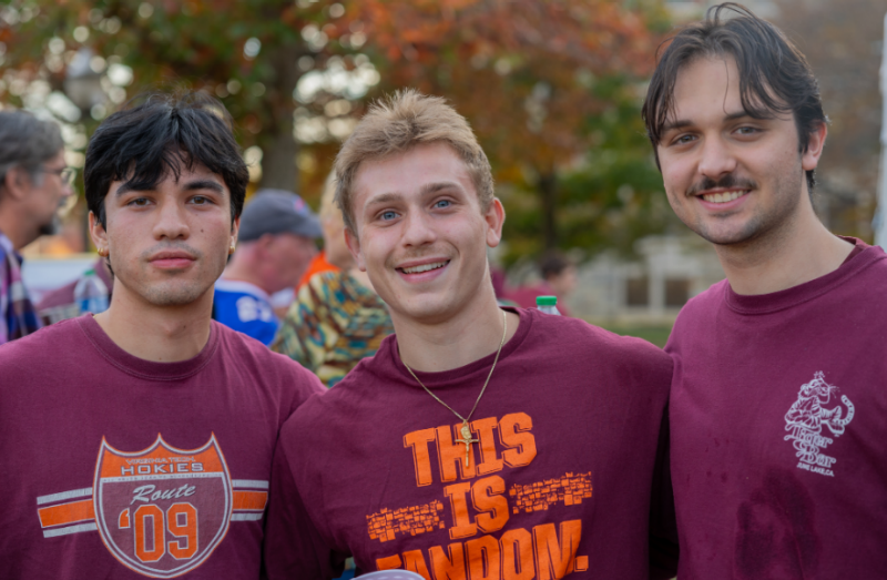 Three young alumni at a tailgate