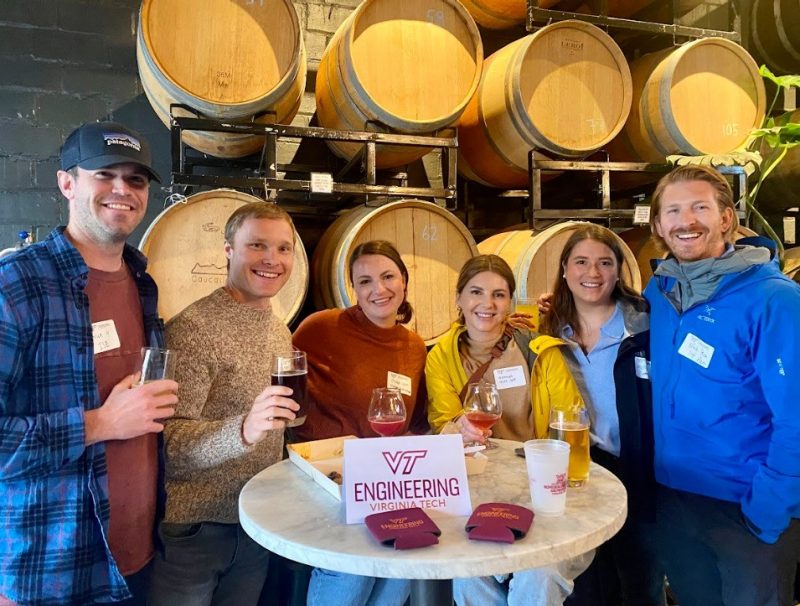 Six alumni smile at a happy hour