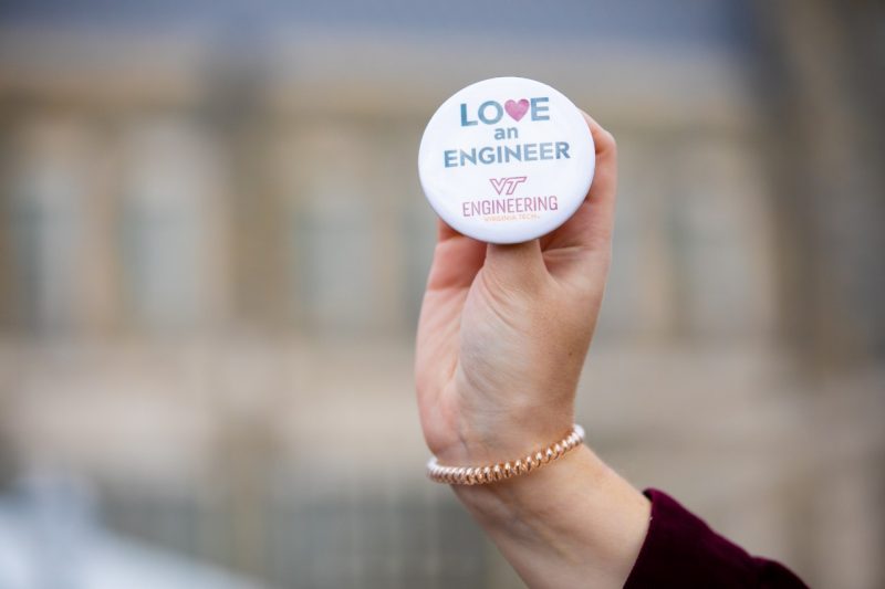 Someone holds a "Love an Engineer" pin