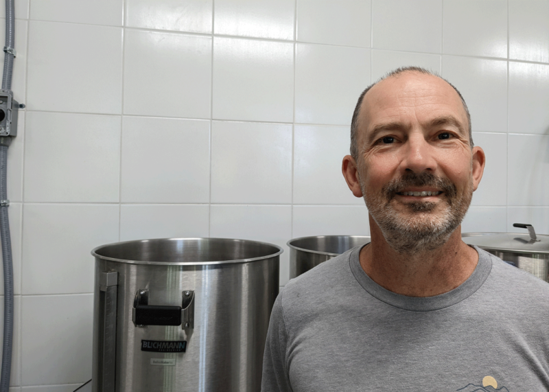 Ed Shore stands in front of his brewing station