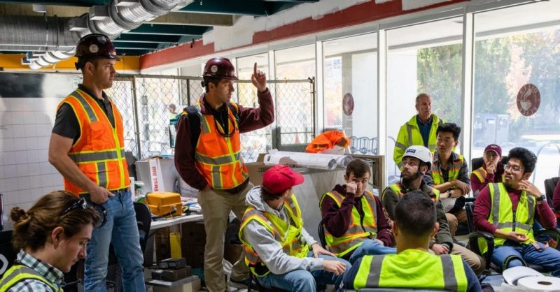 Kyle White (standing at right) leads students on a tour of the Dietrick Hall renovation.