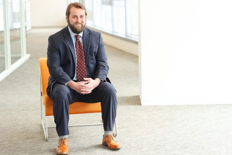 John Robie sits on an orange chair