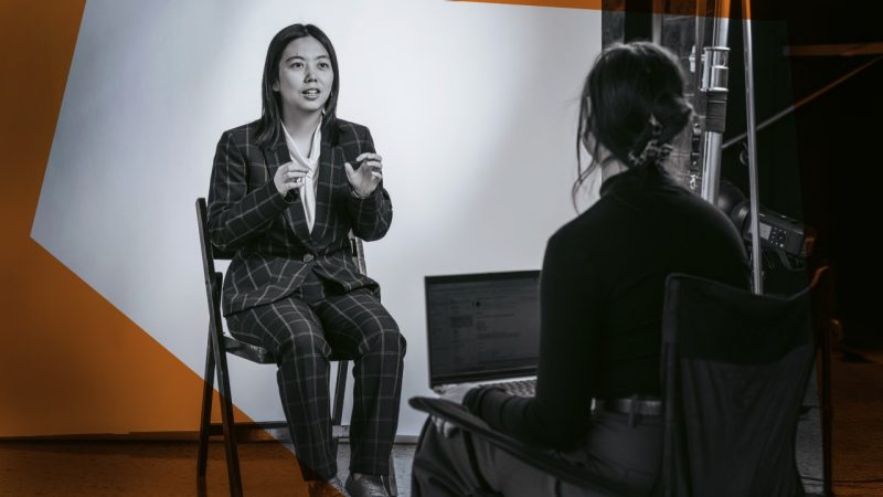 Xuan Wang being interviewed on a photo set.