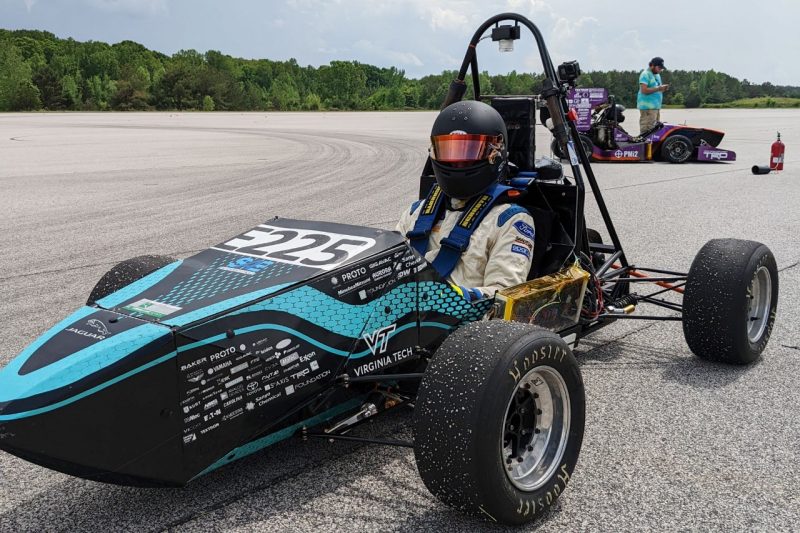 A driver sits in a Formula SAE car.