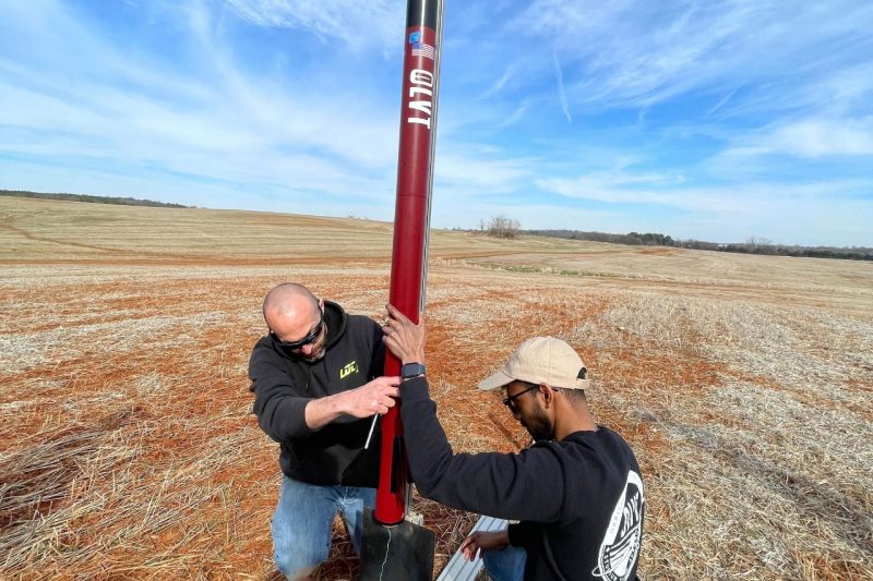 Orbital Launch team members put a rocket on a launch pad.