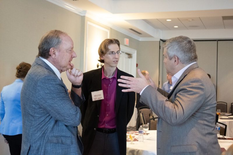 Three gentlemen deep in discussion at Real Estate Advisory Board Meeting