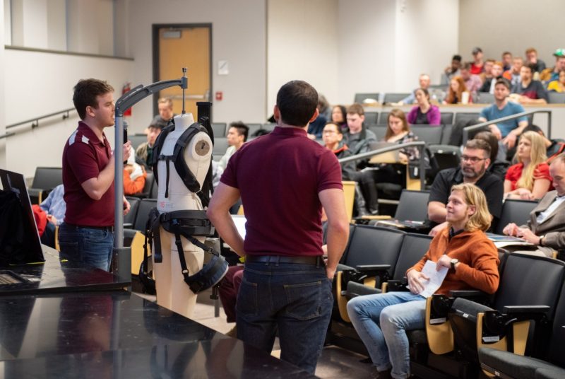 Two members of Maroon Assistive Technologies demonstrate their business concept to the audience at the VT Entrepreneur Challenge.