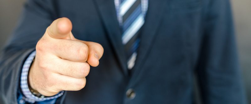 Man in suit pointing at camera